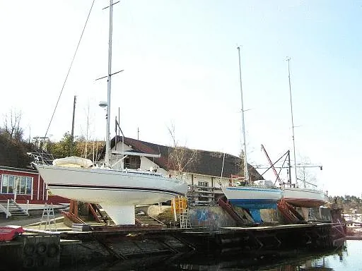 Seilbåter på land ved marina med båthus i bakgrunnen